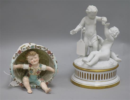 A Parianware putti table centre and a boy sitting in a basket ornament
